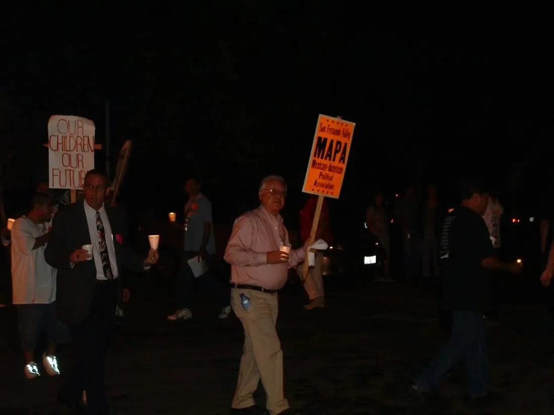 Marchers at night carrying a MAPA sign